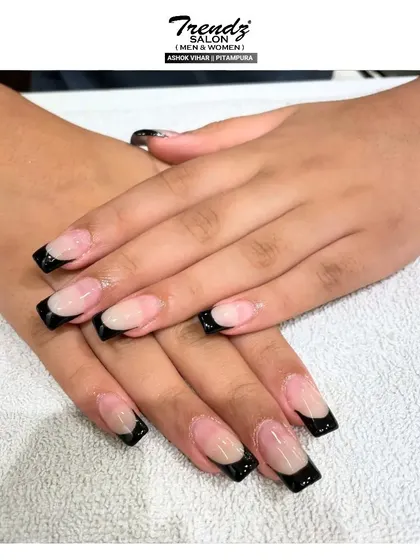 This is a close-up of the bold black French tip manicure on perfectly sculpted square extensions. The high-contrast look is modern, confident, and makes a definite style statement.