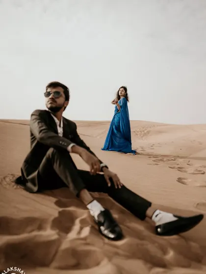 A creative composition with the groom seated in the foreground, giving the shot an editorial feel.