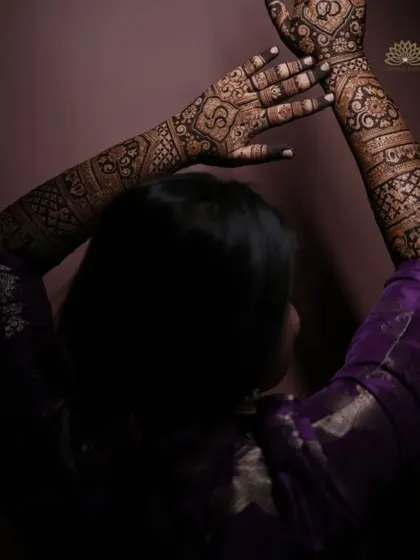 An artistic shot of a client showcasing her full-arm engagement mehndi, with the dark stain beautifully captured.