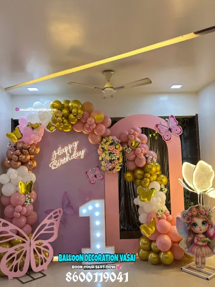 A glamorous butterfly theme for a first birthday. We used a double-arched pink backdrop, a balloon garland with chrome gold and pink, and multiple butterfly props, including a large illuminated one.