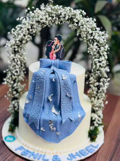 A closer look at the modern wedding cake with an edible fabric drape. The intricate texture on the blue fabric and the delicate silver butterfly details make this a truly special design.