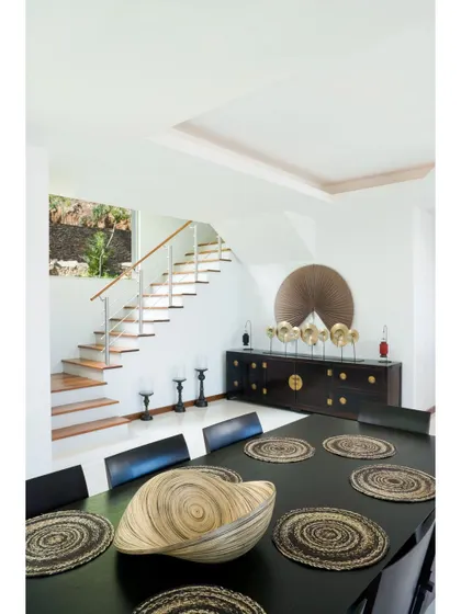 A dining area that embraces natural and rustic elements. The dark wood table, woven placemats, and statement centerpiece create a unique and earthy aesthetic.