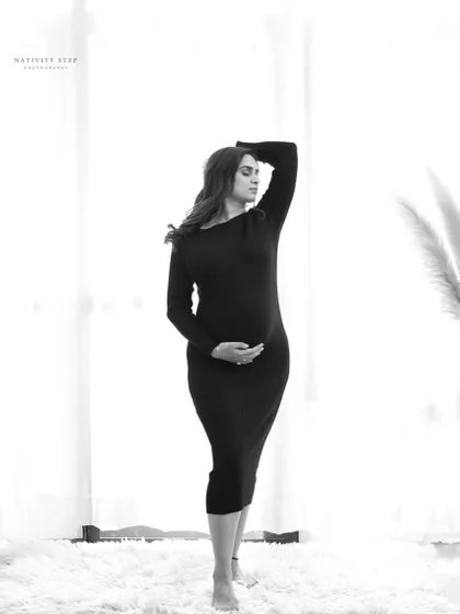 A modern and artistic black and white pose. The high-key background and the strong lines of the pose create a fashionable and striking image.