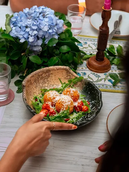 A dish from our Roman-inspired menu: delicate arancini balls served on a bed of greens. We love to create themed culinary events that transport our guests through flavor.