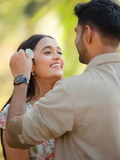 A sweet and gentle moment between Kevin and Reeti. The act of him placing a flower in her hair is a classic romantic gesture, captured beautifully with a focus on her bright smile.