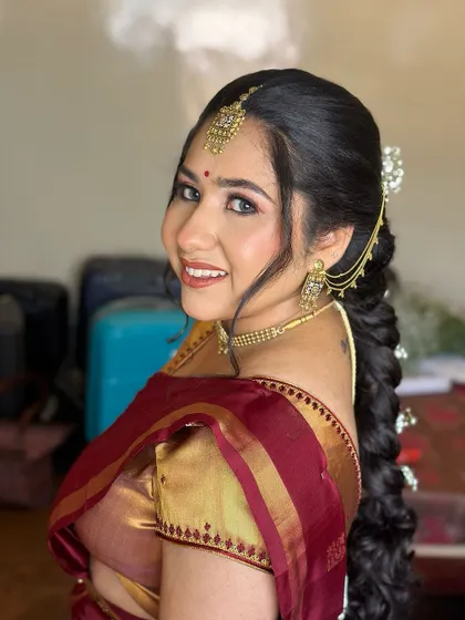 A side profile showcasing the beautiful, intricate braid adorned with baby's breath. The hairstyle perfectly complements the soft and romantic makeup.