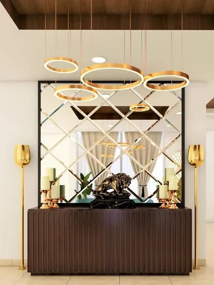 A glamorous foyer with a large, beveled mirror and stunning ring chandeliers. The dark wood console and gold accents create a luxurious and dramatic entrance.
