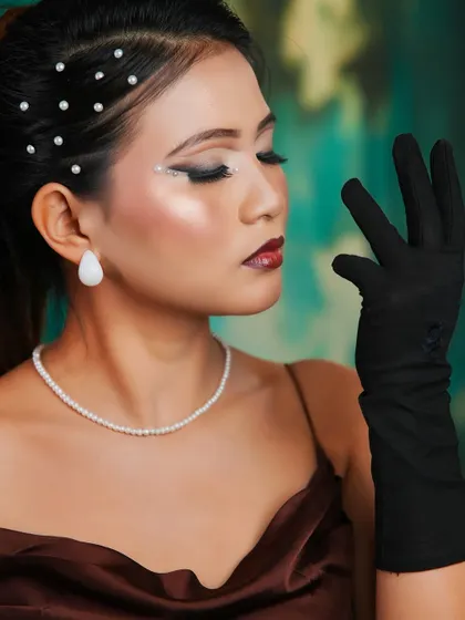 This pose highlights the long black gloves and the overall sophisticated silhouette of this classic look.