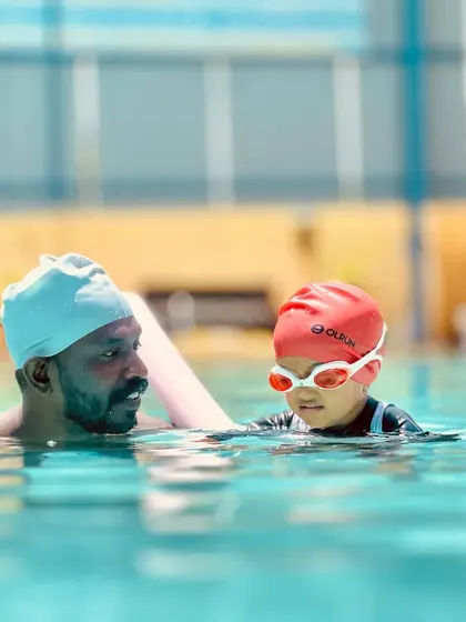 Focused instruction for our youngest learner. Here, a coach provides gentle support while teaching a toddler how to position their body correctly in the water.