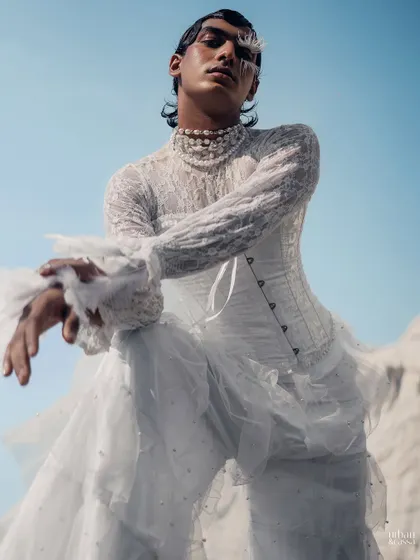 A powerful low-angle shot where the feather makeup and wet-look hair contribute to a commanding, high-fashion presence.