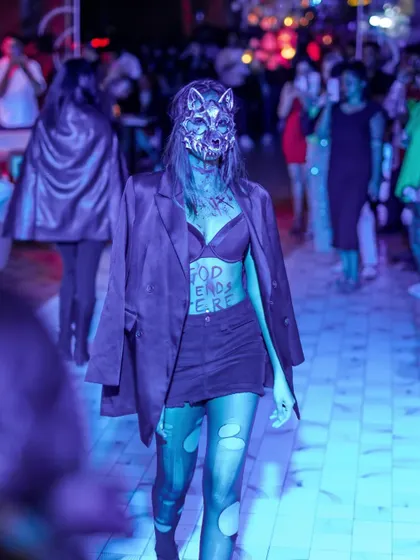 A model in a werewolf mask on the runway, adding a fierce element to the Halloween show.