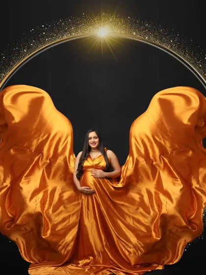 Framed in a circle of light, this mom-to-be looks majestic in a golden gown with fabric tossed to look like wings. A truly celestial portrait.