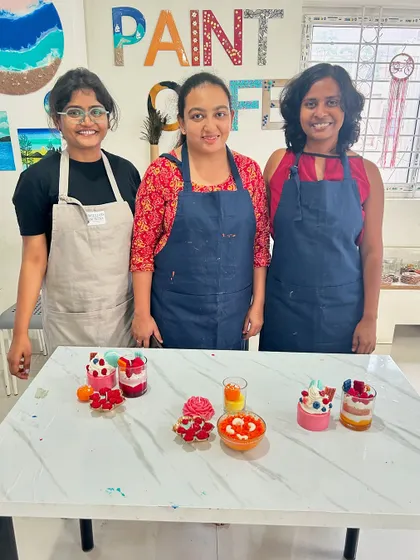 A group of friends proudly displaying their finished candles. It's always fun to see the different designs everyone comes up with.