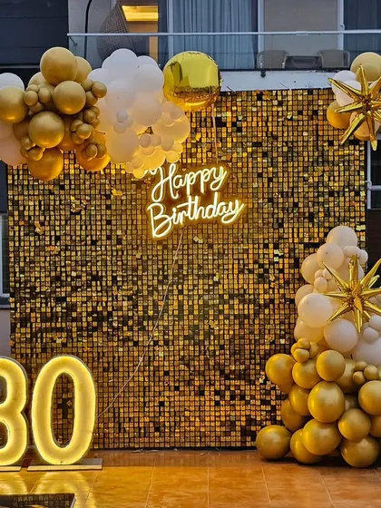 A glamorous 30th birthday setup featuring a full gold sequin shimmer wall, a custom 'Happy Birthday' neon sign, and large light-up marquee numbers. This is one of our most popular backdrops for photos.