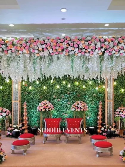 This Vidhi Mandap is a sanctuary where tradition meets artistry. We combined a lush green wall with cascading white florals and rich red seating to create a sacred space that feels both grand and intimate.