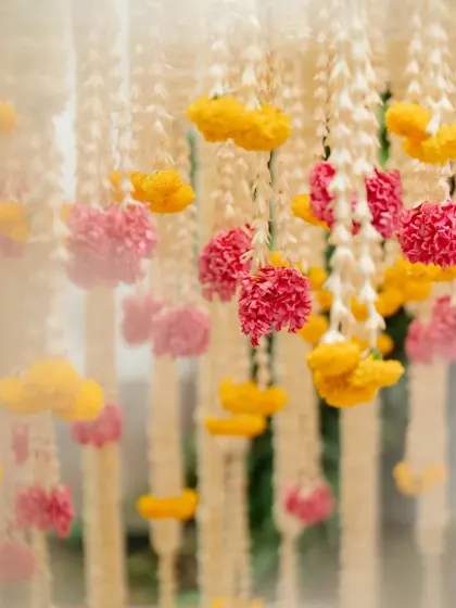 The entire venue becomes a part of the story. Here, hanging floral decorations in the courtyard create a beautiful rhythm, echoing the traditional architecture and filling the space with color and life.