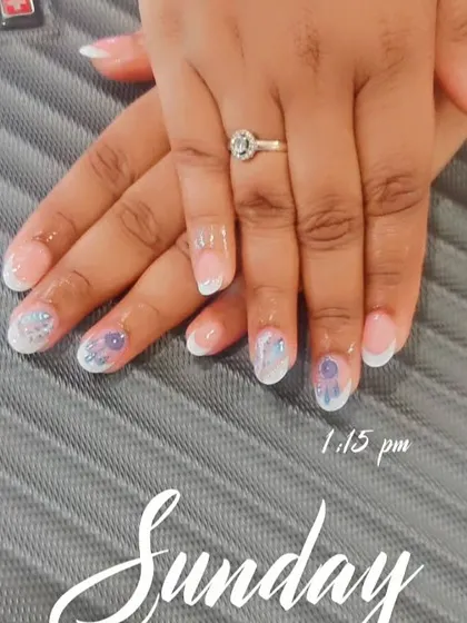 This is another lovely option for an engagement. It's a French manicure with a twist, featuring delicate floral art and glitter on the accent nails to draw attention to the ring.