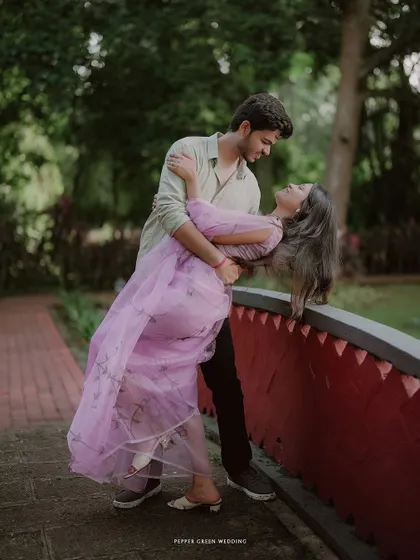 A romantic dip on a bridge for Simran and Pranjal. The flowing fabric of her dress and their loving gaze create a beautiful, dynamic portrait.