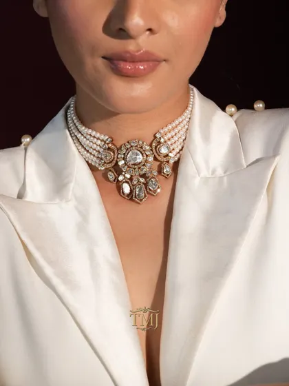 This exquisite polki and pearl choker is the epitome of royal elegance. Paired with a modern outfit like this white blazer, it creates a powerful Indo-western look that is perfect for a welcome dinner or reception.