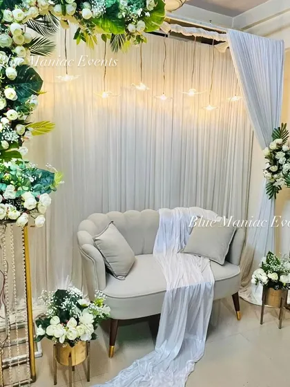 A different angle of the C-shaped arch Roka setup, showing the depth and layering of the floral arrangements and the soft glow of the hanging lights.