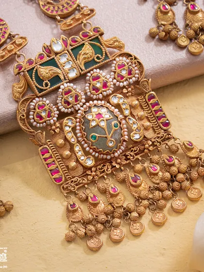 A detailed close-up of the Maharani Haar's central pendant. Observe the fine craftsmanship in the Bikaneri enamel, the setting of the gemstones, and the delicate pearl border, all coming together to create a piece of unapologetically grand, queenly adornment.