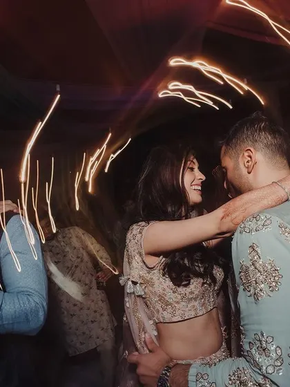 A candid shot of a couple dancing at their cocktail party. The light trails from the camera capture the energy and movement of the celebration.