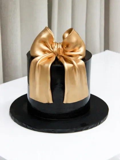 My take on the trending big bow cake, this time in a chic black and gold combination for a sophisticated birthday celebration.
