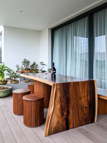 The live-edge table serves as a functional bar and a sculptural work of art, making the deck a truly special part of the home.