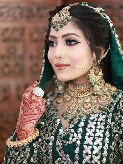 A stunning emerald green bridal look. The eye makeup is a soft smokey look that complements the green in her lehenga and jewelry.