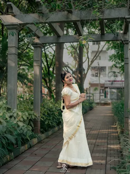 A wide shot in a park setting, showing how the timeless Kerala saree looks beautiful in a natural, outdoor environment.