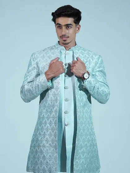 Another view of the light blue sherwani, showing the intricate embroidery on the jacket.
