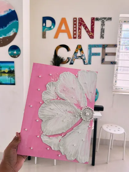 A beautiful example of texture art on canvas, featuring a large white flower with pearl embellishments on a pink background.