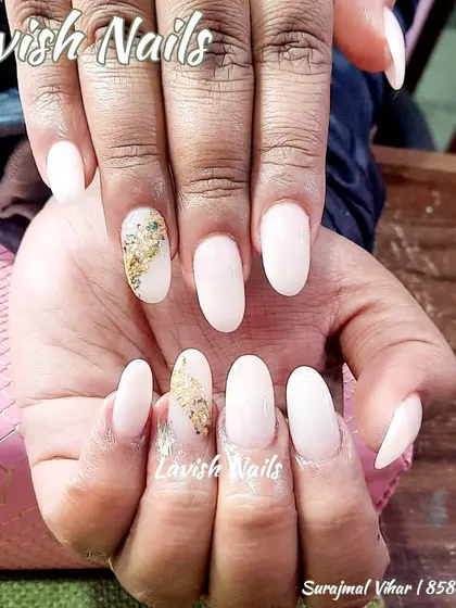 A subtle and chic design with milky white nails and an accent nail featuring a touch of gold foil for a minimalist artistic statement.