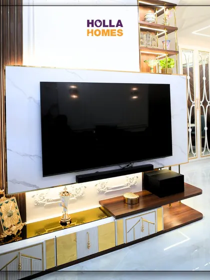 A close-up of the TV unit in the Parisian-themed living room. The combination of white marble, dark wood, and gold accents creates a truly luxurious entertainment center.