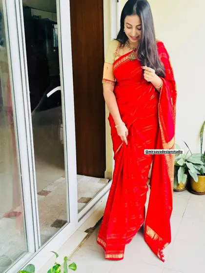 Soundarya in a simple and elegant red saree. The custom-designed blouse adds a touch of class to this timeless look.