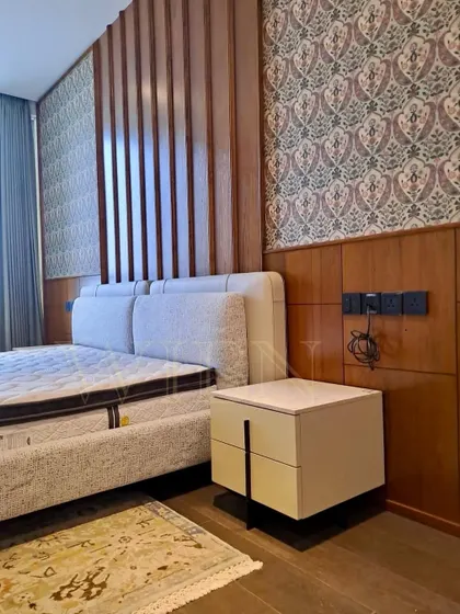 Another angle of the bespoke bed and floating nightstand, showing how the furniture integrates with the architectural elements of the room, like the wood-paneled feature wall.