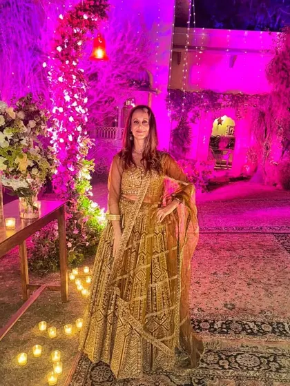 Another shot of our client in the golden-brown lehenga, this time under dramatic pink lighting. The outfit looks stunning in every light.