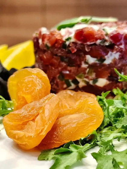 Board goals level: expert! This jewel-toned cheese creation pops with creamy layers, juicy cherry tomatoes, tangy olives, and golden dried apricots for a sweet and savory bite.