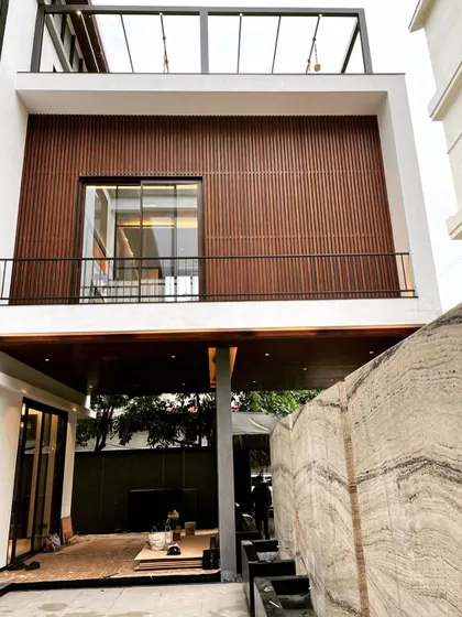 This shot shows the progress on the exterior, with the striking marble boundary wall contrasting with the warm wood facade. Our on-site involvement ensures that material junctions and details are executed precisely as designed.