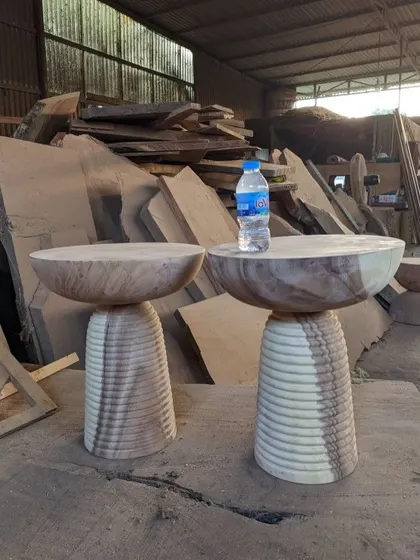 More examples of my custom-carved wooden side tables, showcasing different shapes and the natural patterns of the wood.