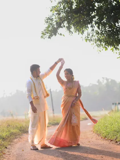 A playful, dancing pose during a pre-wedding shoot. This image captures the joy and movement of the couple against the beautiful morning light.