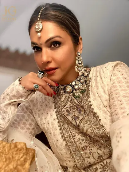 An illuminating elegance. The stunning Isha Koppikar looks absolutely radiant in our grand Polki collection, featuring a statement necklace, matching earrings, and a traditional maang tikka.