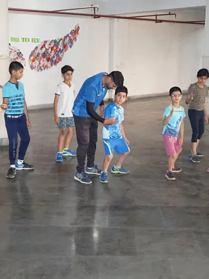 A coach provides hands on correction to a young fencer during a footwork drill. Individual attention is key to our coaching philosophy, ensuring proper technique is developed early.