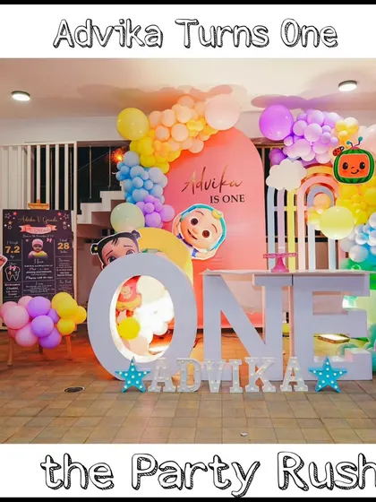 A full view of Advika's Cocomelon-themed first birthday party, showing the complete setup with the "ONE" table, character cutouts, and personalized milestone board.