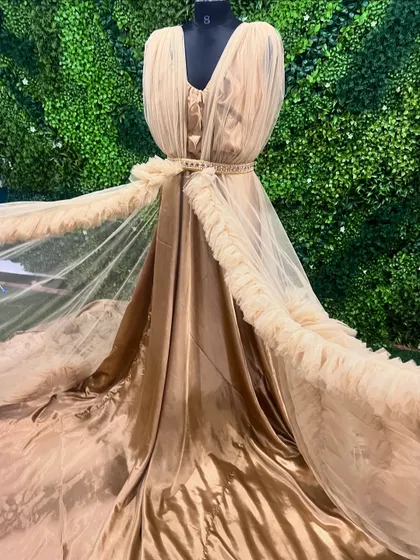 A detailed look at the flowing fabric of our beige ruffle gown. The combination of satin and tulle gives it a luxurious and ethereal feel.
