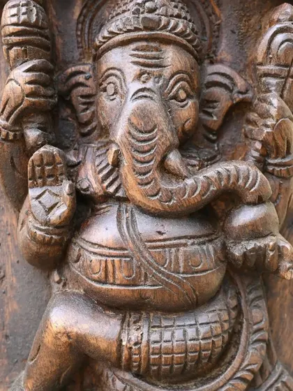 Another form of Ganesha from the vertical panel, this one in a seated posture of blessing. The dark wood grain adds texture and depth.