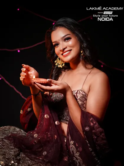 A classic Diwali portrait with a diya. The makeup is warm and golden, reflecting the light of the lamp and the spirit of the festival.