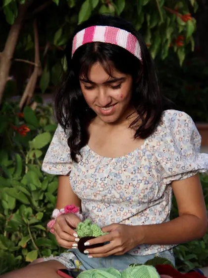 This pink and white striped headband adds a sweet, feminine touch to any outfit. Here I am admiring some of my other crochet creations while wearing it.