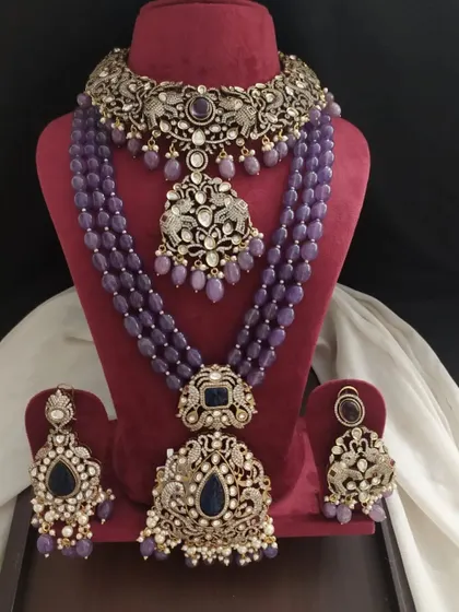 A stunning Victorian set with dark blue stones. The layered necklaces feature peacock and floral motifs, creating a rich and luxurious look perfect for grand occasions.