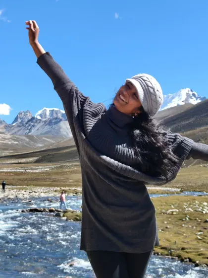 A joyful, celebratory pose in the stunning landscape of Sikkim. This image captures the pure happiness of travel and exploration in the mountains.